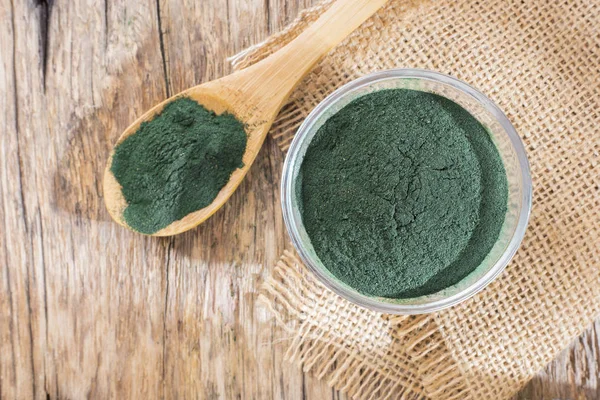 Deniz yosunu toz spirulina ahşap arka plan üzerinde