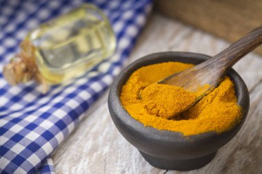 Ahşap arka plan-zerdeçal longa üzerinde bir kasede zemin zerdeçal