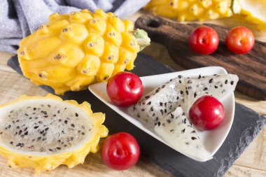 sarı pitahaya ya da ejderha meyve ve ahşap arka plan üzerinde kırmızı erik