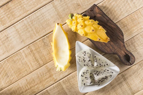 Ahşap arka planda sarı pitahaya ejder meyvesi