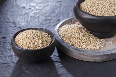 Quinoa Tahıl kaşık ve siyah arka plan üzerine kase