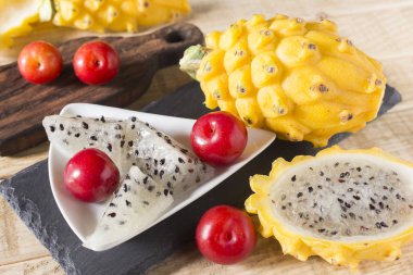 sarı pitahaya ya da ejderha meyve ve ahşap arka plan üzerinde kırmızı erik