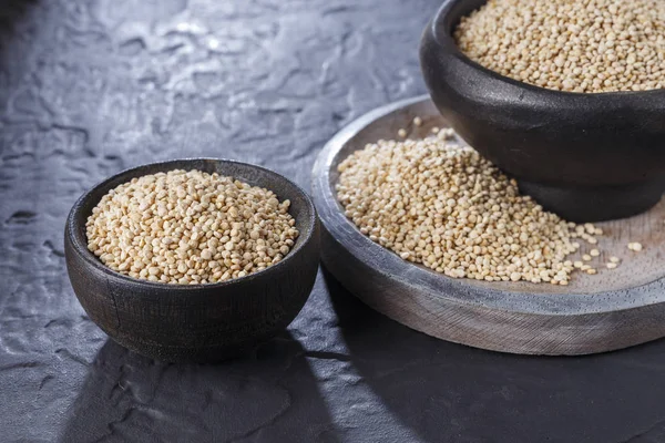 Quinoa Tahıl kaşık ve siyah arka plan üzerine kase