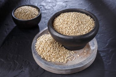 Quinoa Tahıl kaşık ve siyah arka plan üzerine kase