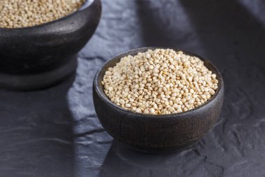 Quinoa Tahıl kaşık ve siyah arka plan üzerine kase