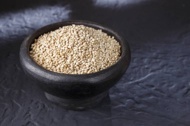 Quinoa Tahıl kaşık ve siyah arka plan üzerine kase