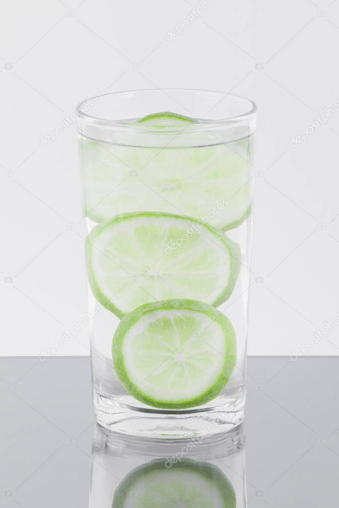 glass with water and lemon isolated on white background.