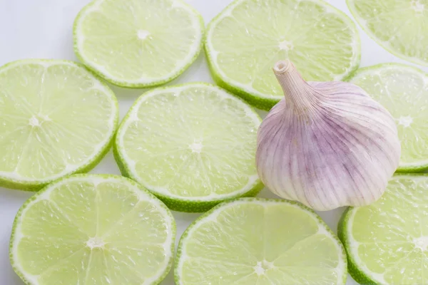 garlic and slices of lemon on white background.