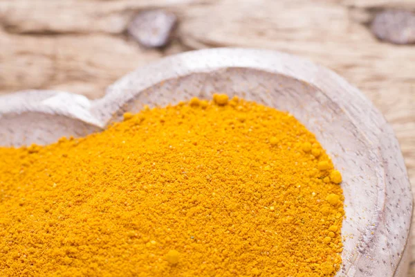Ahşap arka plan üzerinde zerdeçal tozu