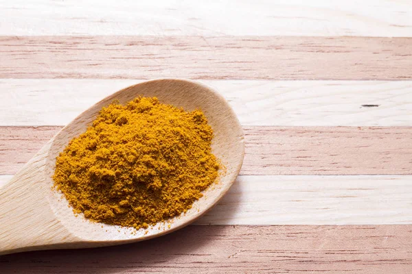 Ahşap arka plan üzerinde zerdeçal tozu