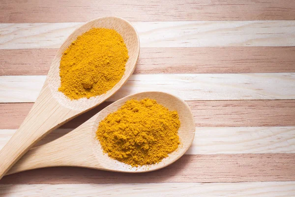 Ahşap arka plan üzerinde zerdeçal tozu