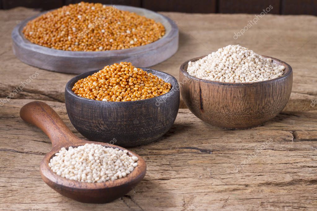 Semillas de quinua y mijo rojo en tazón sobre madera rústica 2024