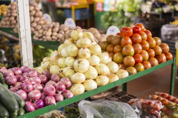 Кучка помидоров и красный и белый лук на рынке — стоковое фото