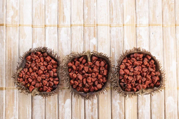 Rustik ahşap üzerinde Annatto tohumları — Stok fotoğraf