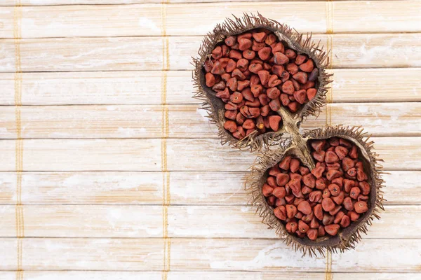 Rustik ahşap üzerinde Annatto tohumları — Stok fotoğraf