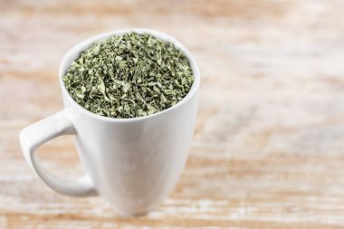 ahşap arka plan üzerinde moringa yaprakları ile beyaz fincan