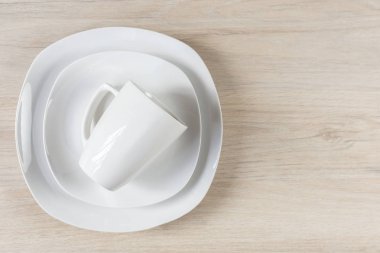 Ahşap arka planda beyaz seramik kaplar ve tabaklar, görüntü