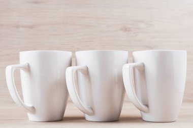 Ahşap arka plan üzerine beyaz seramik bardaklar, görüntü