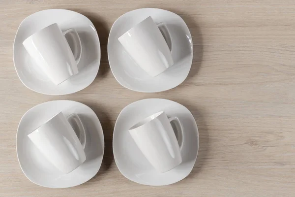 Tazas y platos de cerámica blanca sobre fondo de madera, imagen —  Fotos de Stock