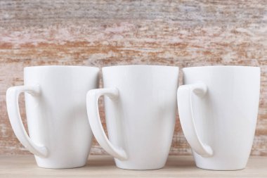 Ahşap arka plan üzerine beyaz seramik bardaklar, görüntü