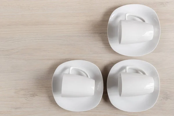 Tazas y platos de cerámica blanca sobre fondo de madera, imagen —  Fotos de Stock