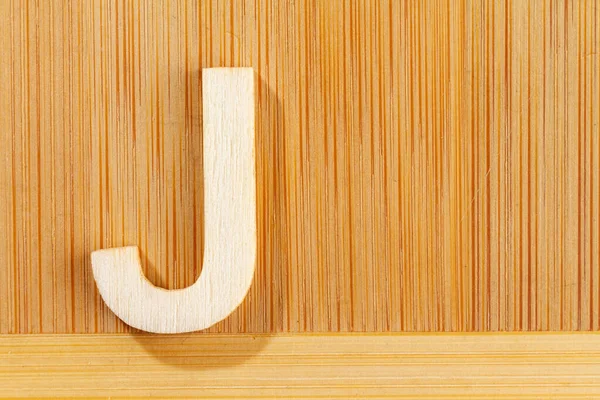 Letter J of wood-made alphabet, top view and space for text — Stock Photo, Image