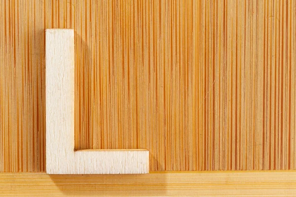 Letter L of wood-made alphabet, top view and space for text — Stock Photo, Image