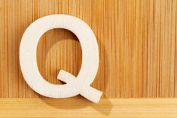 Buchstabe q aus Holz-Alphabet, Draufsicht und Platz für Text — Stockfoto