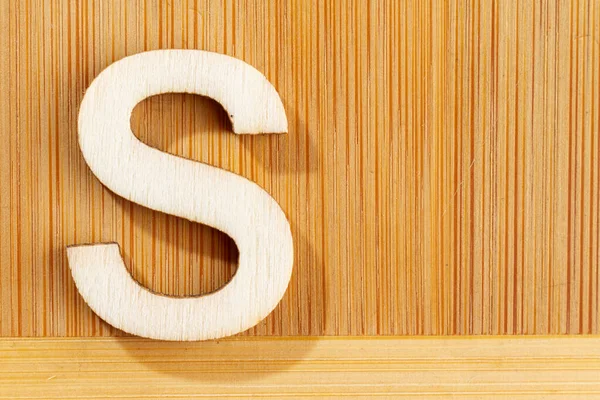 Letter S of wood-made alphabet, top view and space for text — Stock Photo, Image