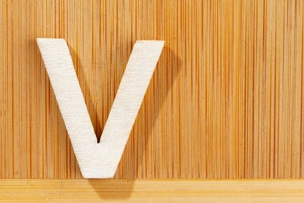 Letter V of wood-made alphabet, top view and space for text — Stock Photo, Image