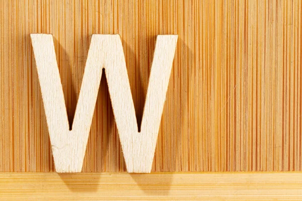 Letter W of wood-made alphabet, top view and space for text — Stock Photo, Image