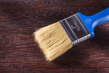 Ahşap arka planda boya fırçası, yakın plan.