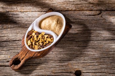 Meyan kökü ve toz, ahşap masanın üzerinde - Glicyrhiza glabra