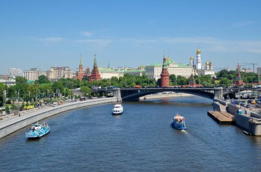 Summer view of the Moscow Kremlin, Prechistenskaya, Bersenevskaya embankments and pleasure boats. Moscow, Russia clipart