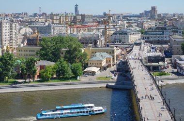 Moscow, Russia - June 4, 2019: The Patriarchal bridge, Moscow, Bersenevskaya embankment and a passing pleasure boat clipart