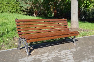 Park'ta siyah ferforje ayaklı boş ahşap boyalı kahverengi renkli bank