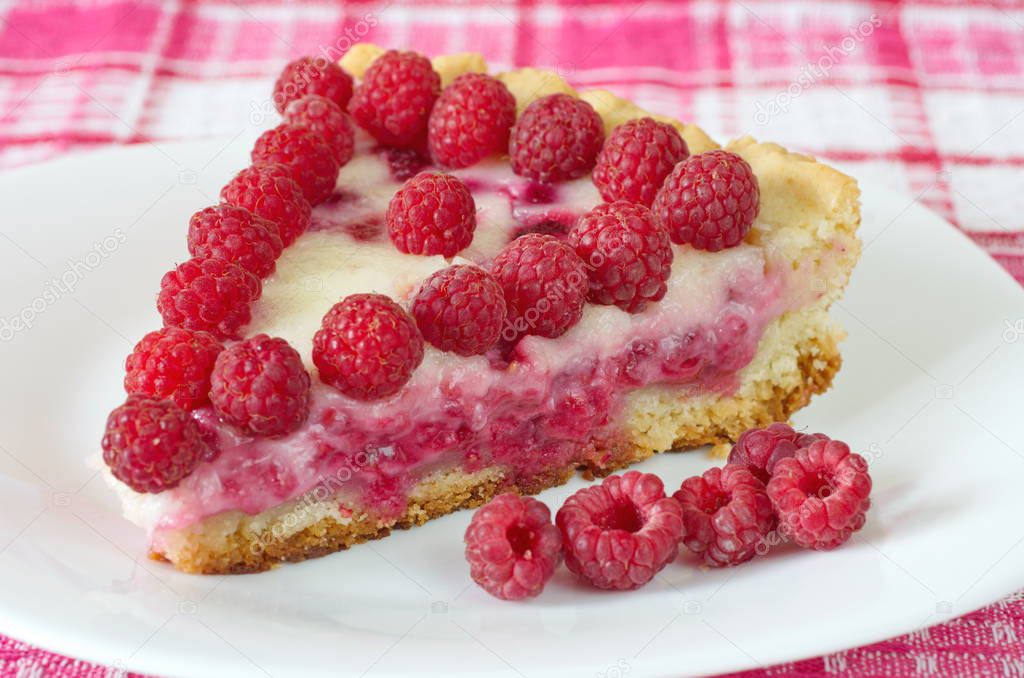 A piece of shortbread pie with raspberry and sour cream on a plate