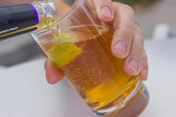 carbonated beverage of amber color with lime in a glass goblet