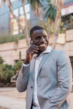 Mutlu Afrikalı Amerikalı menajer ofis dışında bir telefon görüşmesi yapıyor.