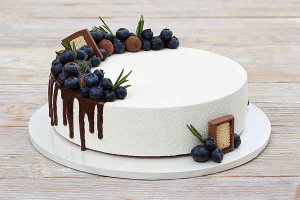 白色慕斯蛋糕装饰浆果 巧克力条纹和糖果在轻木背景特写视图 — 图库照片