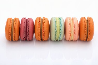 Beyaz arka plan portre görünümünde renkli macarons sürü