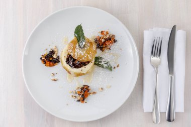 kurutulmuş meyve, bal, ceviz, toz ile bir tabakta pişmiş elma