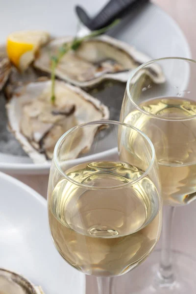 A pair of glasses of white wine and oysters on ice, selective fo — Stock Photo, Image