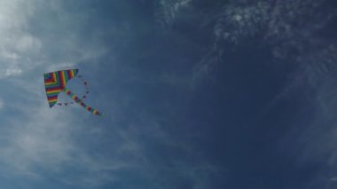 Mavi gökyüzünde uçan gökkuşağı uçurtması