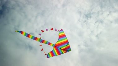 Mavi gökyüzünde uçan gökkuşağı uçurtması