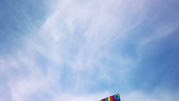 Tęczowy latawiec lecący na błękitnym niebie — Wideo stockowe