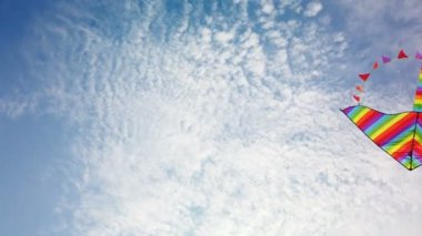 Mavi gökyüzünde uçan gökkuşağı uçurtması