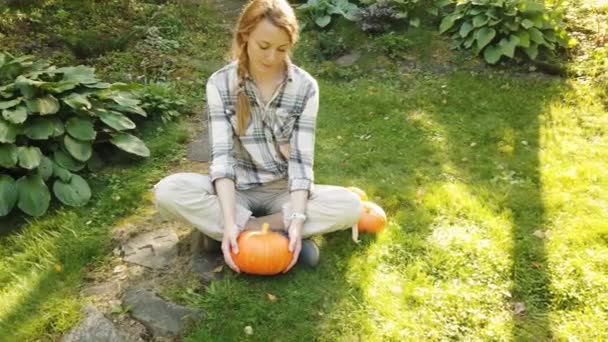 Beautiful woman in the garden with pumpkins — Stock Video