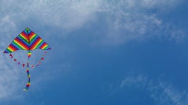 Mavi gökyüzünde uçan gökkuşağı uçurtması