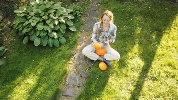 Mooie vrouw in de tuin met pompoenen — Stockvideo